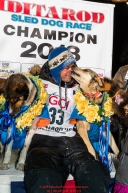 Joar Leifseth Ulsom poses with his lead dogs Russeren (left) and Olive on the winner's podium at the finish line in Nome, Alaska early on Wednesday morning March 14th as he wins the 46th running of the 2018 Iditarod Sled Dog Race.  He finished in 9 days 12 hours 00 minutes and 00 secondsPhoto by Jeff Schultz/SchultzPhoto.com  (C) 2018  ALL RIGHTS RESERVED
