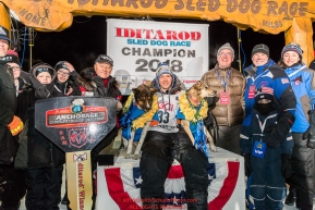 Joar Leifseth Ulsom poses with his lead dogs Russeren (left) and Olive and Iditarod sponsors on the winner's podium at the finish line in Nome, Alaska early on Wednesday morning March 14th as he wins the 46th running of the 2018 Iditarod Sled Dog Race.  He finished in 9 days 12 hours 00 minutes and 00 secondsPhoto by Jeff Schultz/SchultzPhoto.com  (C) 2018  ALL RIGHTS RESERVED