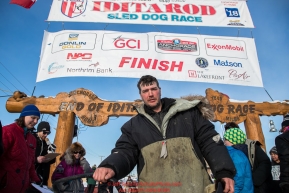 Ray Redington Jr. poses at his sled at the Nome finish line on Wednesday March 14th in the 46th running of the 2018 Iditarod Sled Dog Race.  Photo by Jeff Schultz/SchultzPhoto.com  (C) 2018  ALL RIGHTS RESERVED