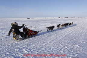 Thursday March 15, 2012   Lance Mackey uses two trail markers as ski poles to push himself down trail as he runs just inland from the sea ice of the Bering Sea nearing the finish in Nome at Ft. Davis. Iditarod 2012.