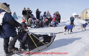 Thursday March 15, 2012    Pre-school kids and their teachers from the local day care watch Anjanette Steer run up the bank from the   Bering Sea nearing the finish in Nome. Iditarod 2012.