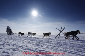 Thursday March 15, 2012   Braxton Peterson runs past a tripod marker just inland from of the Bering Sea 5 miles from the finish in Nome. Iditarod 2012.