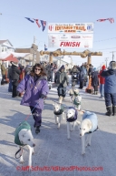 Thursday March 15, 2012   Jim Lanier 's wife Anna Bondaranko leads Jim 's team from the finish chute on Front Street in Nome to the dog lot as their son Jimmy rides the sled.  Iditarod 2012.