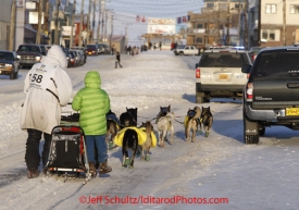 Thursday March 15, 2012    Jerry Sousa and his son Nicholas drive the team down Front street with a police escort as they near the finish in Nome. Iditarod 2012.