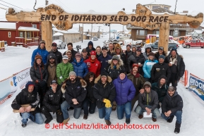 A large portion of the mushers who completed the 2014 Iditarod pose for a photo under the burl arch finish line in Nome on Saturday March 15 during the 2014 Iditarod Sled Dog Race.PHOTO (c) BY JEFF SCHULTZ/IditarodPhotos.com -- REPRODUCTION PROHIBITED WITHOUT PERMISSION