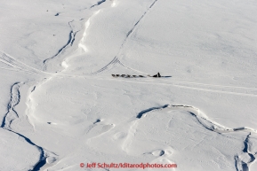 A team runs down the trail on the bank of the Yukon River after leaving the Nulato checkpoint on the afternoon of Sunday  March 15, 2015 during Iditarod 2015.  (C) Jeff Schultz/SchultzPhoto.com - ALL RIGHTS RESERVED DUPLICATION  PROHIBITED  WITHOUT  PERMISSION