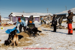 Volunteer vets wait for Martin Buser to finish laying straw for the dogs before they examine his team shortly after his arrival at the Kaltag checkpoint on the afternoon of Sunday  March 15, 2015 during Iditarod 2015.  (C) Jeff Schultz/SchultzPhoto.com - ALL RIGHTS RESERVED DUPLICATION  PROHIBITED  WITHOUT  PERMISSION