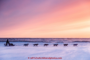 Aaron Burmeister runs on the slough in 30 mph wind leaving the Unalakleet checkpoint at sunset on Sunday  March 15, 2015 during Iditarod 2015.  (C) Jeff Schultz/SchultzPhoto.com - ALL RIGHTS RESERVED DUPLICATION  PROHIBITED  WITHOUT  PERMISSION