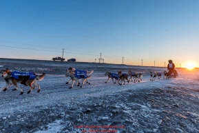 Aliy Zirkle runs on the trail on the Bering Sea shoreline at sunrise just a few miles before the finish  in Nome for a third place finish on Tuesday March 15th during the 2016 Iditarod.  Alaska    Photo by Jeff Schultz (C) 2016  ALL RIGHTS RESERVED
