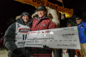 Dallas Seavey is presented with the winning check from Donlin Gold sponsor Stan Foo after winning the 44th running of the Iditarod Sled Dog Race in Nome on Tuesday March 15th during the 2016 Iditarod in record time of 8 Days 11 hours 20 minutes 16 seconds   Photo by Jeff Schultz (C) 2016  ALL RIGHTS RESERVED