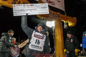Dallas Seavey holds up his winners check after completing the 44th running of the Iditarod Sled Dog Race in Nome on Tuesday March 15th during the 2016 Iditarod in record time of 8 Days 11 hours 20 minutes 16 seconds Photo by Jeff Schultz (C) 2016  ALL RIGHTS RESERVED