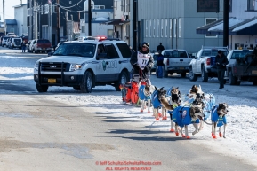 Norwegian musher Ralph Johannessen is escorted down Front Street in Nome by a police vehicle as he makes his way to the finish line on Tuesday March 15th during the 2016 Iditarod.  Alaska    Photo by Jeff Schultz (C) 2016  ALL RIGHTS RESERVED