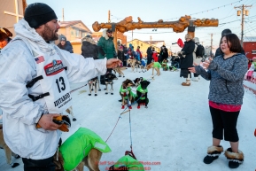 Sebastien Vergnaud tosses a used dog bootie to Kierra Scott in the finish line area in Nome during the 2017 Iditarod on Wednesday March 15, 2017.Photo by Jeff Schultz/SchultzPhoto.com  (C) 2017  ALL RIGHTS RESERVED