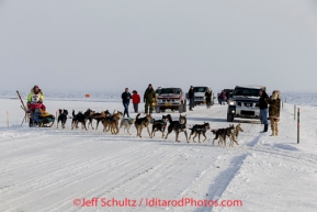 Monica Zappa on the trail just a few miles from the finish line crosses the road as spectators cheer her on as she nears Nome on Saturday March 15 during the 2014 Iditarod Sled Dog Race.PHOTO (c) BY JEFF SCHULTZ/IditarodPhotos.com -- REPRODUCTION PROHIBITED WITHOUT PERMISSION