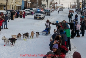 Marcelle Fressineau runs into the finish chute to claim 49th and last place at Nome on Saturday March 15 during the 2014 Iditarod Sled Dog Race.PHOTO (c) BY JEFF SCHULTZ/IditarodPhotos.com -- REPRODUCTION PROHIBITED WITHOUT PERMISSION