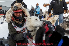 Marcelle Fressineau gives her lead dog a hug in the finish chute shorlty after finishing in 49th and last place at Nome on Saturday March 15 during the 2014 Iditarod Sled Dog Race.PHOTO (c) BY JEFF SCHULTZ/IditarodPhotos.com -- REPRODUCTION PROHIBITED WITHOUT PERMISSION