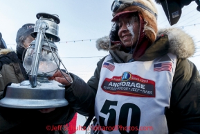 Marcelle Fressineau extinguishes the widow's lamp signifying the last musher is off the trail shorlty after she came in last and 49th place into Nome on Saturday March 15 during the 2014 Iditarod Sled Dog Race.PHOTO (c) BY JEFF SCHULTZ/IditarodPhotos.com -- REPRODUCTION PROHIBITED WITHOUT PERMISSION