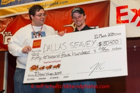 Dallas Seavey gets his winner's check from Scott A. Johnson with Wells Fargo Bank Alaska at the musher 's finishers banquet in Nome on Sunday March 16 after the 2014 Iditarod Sled Dog Race.PHOTO (c) BY JEFF SCHULTZ/IditarodPhotos.com -- REPRODUCTION PROHIBITED WITHOUT PERMISSION