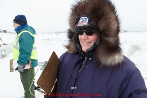 Volunteer Comms, Darla Pindell, waits patiently for a team to arrive in the evening on the ice at the Unalakleet checkpoint on Monday March 16, 2015 during Iditarod 2015.  (C) Jeff Schultz/SchultzPhoto.com - ALL RIGHTS RESERVED DUPLICATION  PROHIBITED  WITHOUT  PERMISSION