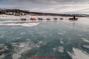 Michelle Phillips runs on slough ice in 30 mph wind several miles after leaving the Unalakleet checkpoint on Monday March 16, 2015 during Iditarod 2015.   (C) Jeff Schultz/SchultzPhoto.com - ALL RIGHTS RESERVED DUPLICATION  PROHIBITED  WITHOUT  PERMISSION