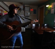 Andrea Irrigoo sings plays her guitar, Dutches from Dutch, at the Pingo Bakery Seafood House in Nome AK Iditarod as people wait for the first Iditarod team to arrive on Monday, March 16, 2020. Irrigoo learned to play her guitar while working at a crab processing plant in Kodiak thus the name. (Photo by Bob Hallinen)