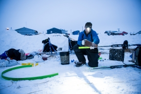 Jason Campeau, changing his sled runner plastic early morning to head up the coast to Nome, March 16th, 2020.