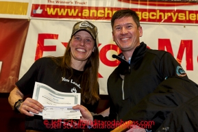 BBNC president Jason Metrokin pressents the Bristol Bay Native Corporation Fish First Award to Aliy Zirkle at the musher 's finishers banquet in Nome on Sunday March 16 after the 2014 Iditarod Sled Dog Race.PHOTO (c) BY JEFF SCHULTZ/IditarodPhotos.com -- REPRODUCTION PROHIBITED WITHOUT PERMISSION