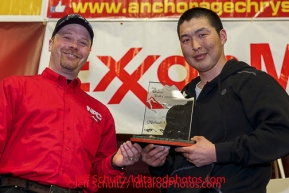 Aaron Burmeister presents the Sportsmanship Award to Mike Williams Jr. at the musher 's finishers banquet in Nome on Sunday March 16 after the 2014 Iditarod Sled Dog Race.PHOTO (c) BY JEFF SCHULTZ/IditarodPhotos.com -- REPRODUCTION PROHIBITED WITHOUT PERMISSION
