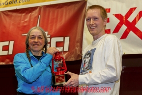 Wells Fargo, Tyler Hull, presents Marcelle Fresineau with the Red Lantern Award at the musher 's finishers banquet in Nome on Sunday March 16 after the 2014 Iditarod Sled Dog Race.PHOTO (c) BY JEFF SCHULTZ/IditarodPhotos.com -- REPRODUCTION PROHIBITED WITHOUT PERMISSION