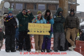 Fans and friends of Christine Roalofs cheer her into the finish chute as she finishes in last place and is winner of the Red Lantern Award on Front Street in Nome.  Iditarod Sled Dog Race 2013Photo by Jeff Schultz copyright 2013 DO NOT REPRODUCE WITHOUT PERMISSION