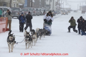 Christine Roalofs runs on Front Street and into the finish chute in Nome to finish in last place and be the winner of the Red Lantern Award   Iditarod Sled Dog Race 2013Photo by Jeff Schultz copyright 2013 DO NOT REPRODUCE WITHOUT PERMISSION