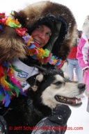 Christine Roalofs who finished in last place and winner of the Red Lantern Award gives her lead dog a big hug on Front Street in Nome.  Iditarod Sled Dog Race 2013Photo by Jeff Schultz copyright 2013 DO NOT REPRODUCE WITHOUT PERMISSION