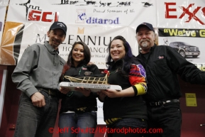 Lance Mackey (Left) receives the Dorothy G. Page GCI Halfway  award from Vanessa Connors, Mercie McGuffey & Gary Samuelson of GCI at the musher awards banquet in Nome on Sunday March 17, 2013.  Iditarod Sled Dog Race 2013Photo by Jeff Schultz copyright 2013 DO NOT REPRODUCE WITHOUT PERMISSION