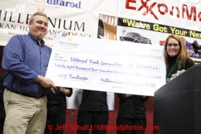 Millenium Hotel Alaska manager Carol Fraser presents a check from a fundraiser at the hotel for $24,449.20  to ITC president Andy Baker at the musher awards banquet in Nome on Sunday March 17, 2013.  Iditarod Sled Dog Race 2013Photo by Jeff Schultz copyright 2013 DO NOT REPRODUCE WITHOUT PERMISSION