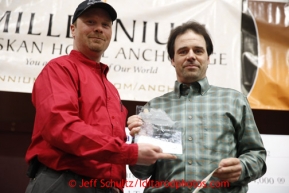 Cym Smyth (righ) receives the Sporstmanship award from IOFC president Aaron Burmeister at the musher awards banquet in Nome on Sunday March 17, 2013.  Iditarod Sled Dog Race 2013Photo by Jeff Schultz copyright 2013 DO NOT REPRODUCE WITHOUT PERMISSION