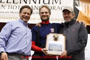 Volunteer veterinarians Dirsko von Pfeil (middle) and Sterling Thomas (right) receive the Golden Stethascope award from Martin Buser at the musher awards banquet in Nome on Sunday March 17, 2013.  Iditarod Sled Dog Race 2013Photo by Jeff Schultz copyright 2013 DO NOT REPRODUCE WITHOUT PERMISSION