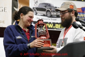 Christine Roaloafs receives the Red Lantern award from Wells Fargo representative Scott A. Johnson at the musher awards banquet in Nome on Sunday March 17, 2013.  Iditarod Sled Dog Race 2013Photo by Jeff Schultz copyright 2013 DO NOT REPRODUCE WITHOUT PERMISSION