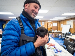 A snow machiner travelling the Iditarod trail meets a local puppy in Koyuk, AK on March 17, 2020.
