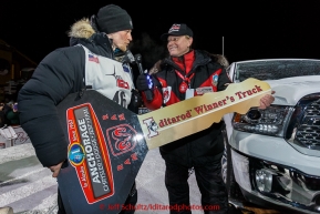 Dallas Seavey recieves the key to his new Dodge Truck from Anchorage Chrysler Dodge sponsor rep Chuck Talskey after winning his 3rd Iditarod in 8 days 18 hours 13 minutes 6 seconds on Wednesday March 18, 2015 during Iditarod 2015.  (C) Jeff Schultz/SchultzPhoto.com - ALL RIGHTS RESERVED DUPLICATION  PROHIBITED  WITHOUT  PERMISSION