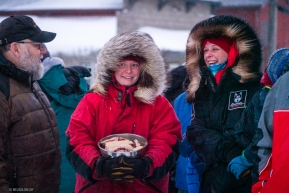Aily Zirkle's family members chat with Mark Nordman of the Iditarod with fresh dog treats in hand.