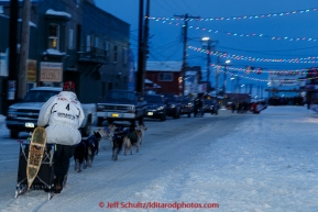 Martin Buser runs down Front Street on his way toward the finish line in Nome on Thursday March 19, 2015 during Iditarod 2015.  (C) Jeff Schultz/SchultzPhoto.com - ALL RIGHTS RESERVED DUPLICATION  PROHIBITED  WITHOUT  PERMISSION