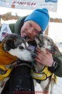 Mats Pettersson hugs his leaders at the finish line in Nome on Thursday March 19, 2015 during Iditarod 2015.  (C) Jeff Schultz/SchultzPhoto.com - ALL RIGHTS RESERVED DUPLICATION  PROHIBITED  WITHOUT  PERMISSION