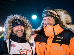Tom Frode Johansen is greeted by Qrill teammate and Iditarod winner Thomas Waerner after crossing the finish line in the early hours of March 19, 2020 (Nome, AK).