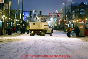 A musher is guided onto 4th avenue by parking volunteers prior to the ceremonial start of the Iditarod sled dog race in downtown Anchorage Saturday, March 2, 2013. Photo (C) Jeff Schultz/IditarodPhotos.com  Do not reproduce without permission