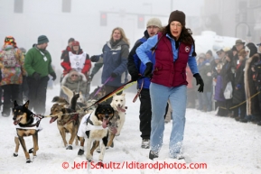 Dog Handlers for Kelley Griffin bring her team down 4rth avenue to the ceremonial start line of the Iditarod sled dog race in downtown Anchorage Saturday, March 2, 2013. Photo (C) Jeff Schultz/IditarodPhotos.com  Do not reproduce without permission