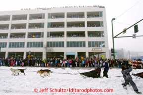 Cindy Gallea runs down 4th avenue as spectators line the parking garage to watch during the ceremonial start of the Iditarod sled dog race Anchorage Saturday, March 2, 2013. Photo (C) Jeff Schultz/IditarodPhotos.com  Do not reproduce without permission