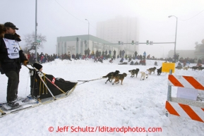 Gerry Willomitzer runs on 4th avenue at Cordova street in the fog as spectaors line the streets during the ceremonial start of the Iditarod sled dog race Anchorage Saturday, March 2, 2013. Photo (C) Jeff Schultz/IditarodPhotos.com  Do not reproduce without permission