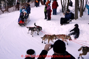 Spectators watch Angie Taggart round the bend at the Goose Lake turn during the ceremonial start of the Iditarod sled dog race Anchorage Saturday, March 2, 2013. Photo (C) Jeff Schultz/IditarodPhotos.com  Do not reproduce without permission