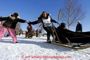 Cindy Abbott leans out to give a young race fan a high-five along the bike/ski trail near the Native hospital during the ceremonial start of the Iditarod sled dog race Anchorage Saturday, March 2, 2013. Photo (C) Jeff Schultz/IditarodPhotos.com  Do not reproduce without permission