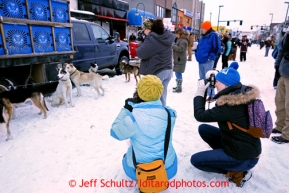 Onlookers photograph a team on 4th avenue prior to the ceremonial start of the Iditarod sled dog race in downtown Anchorage Saturday, March 2, 2013. Photo (C) Jeff Schultz/IditarodPhotos.com  Do not reproduce without permission